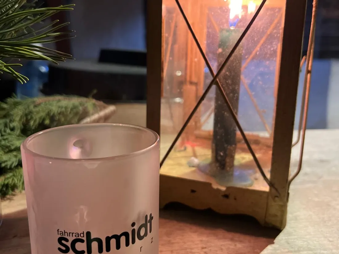 Glühweinbecher mit Fahrrad-Schmidt-Logo neben einer Laterne