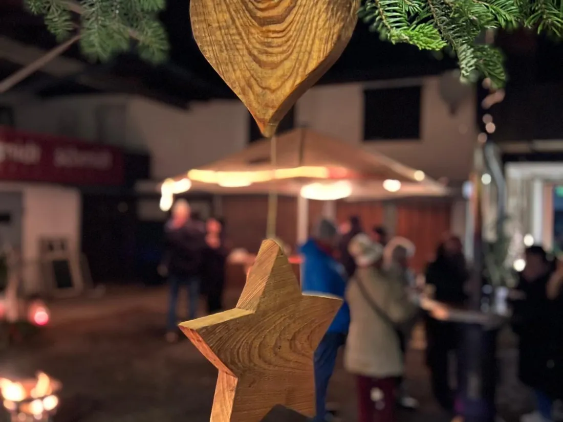 Holzherz und Stern, dahinter Besucher im Hof