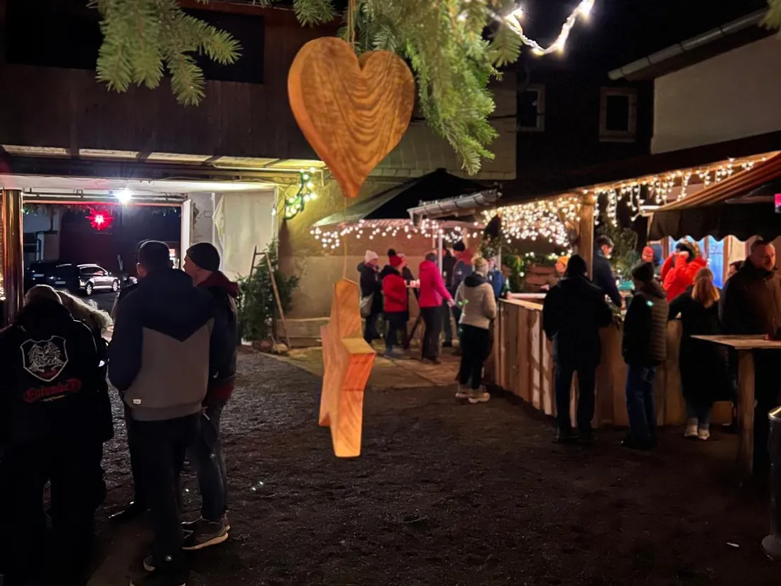 Besucher unter Lichterketten im Hof